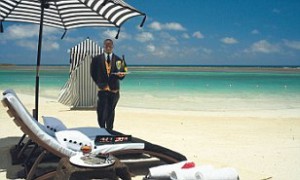 Waiter at Sandals Golf Resort serving champagne on the beach.